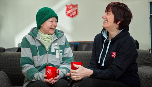Salvation Army staff member at a centre drinking tea with a woman