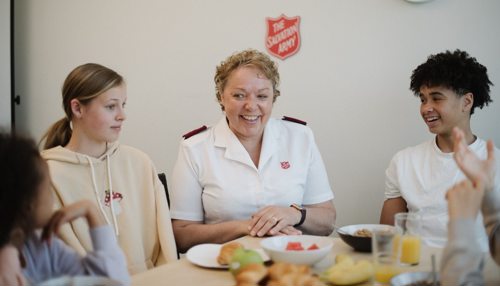 Salvation Army officer at the table with children at a centre